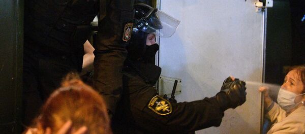 Сотрудник ОМОНа применяет баллончик со слезоточивым газом против участника акции протеста в Минске - 俄羅斯衛星通訊社