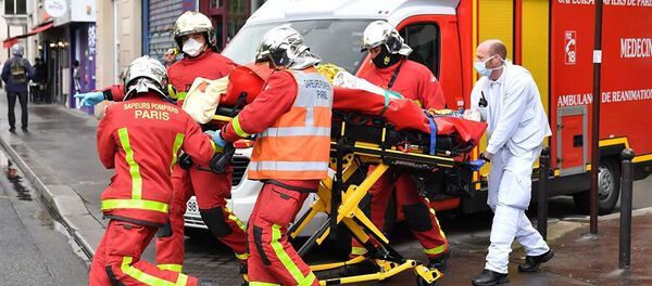 Французские пожарные несут раненого возле бывшего офиса французского сатирического журнала Charlie Hebdo в Париже - 俄羅斯衛星通訊社