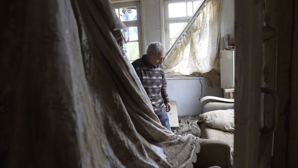 Местный житель показывает комнату пострадавшего дома в городе Мартуни после обстрела  - 俄羅斯衛星通訊社