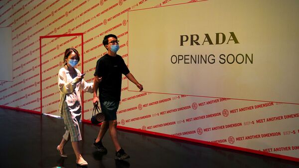 Люди проходят мимо магазина Prada, который скоро откроется в торговом центре - 俄罗斯卫星通讯社