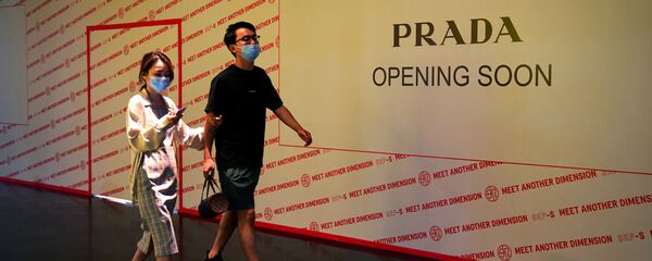 Люди проходят мимо магазина Prada, который скоро откроется в торговом центре - 俄羅斯衛星通訊社
