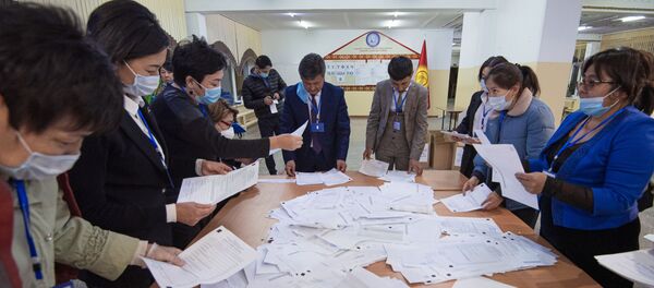 Члены участковой избирательной комиссии подсчитывают бюллетени на избирательном участке №1327 в школе-гимназии №5 в городе Бишкек.  - 俄罗斯卫星通讯社