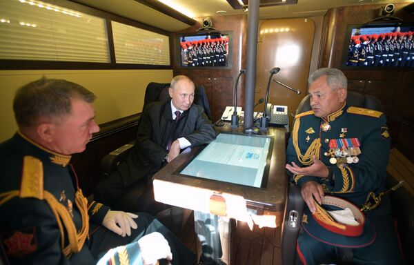 俄罗斯总统兼武装力量最高统帅弗拉基米尔•普京、俄罗斯国防部长谢尔盖•绍伊古（右）和西部军区司令亚历山大•朱拉夫列夫（左）在穿越芬兰湾的总统快艇的船舱内 - 俄罗斯卫星通讯社
