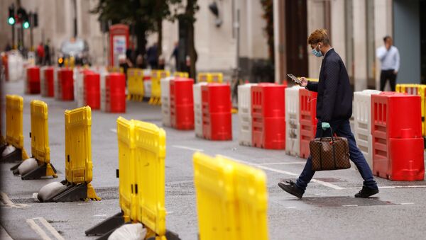Мужчина в защитной маске переходит дорогу в Лондоне - 俄罗斯卫星通讯社