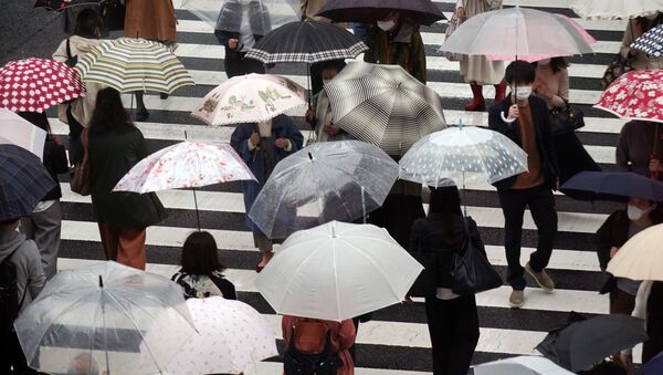 Люди на пешеходном переходе под дождем в Токио - 俄罗斯卫星通讯社