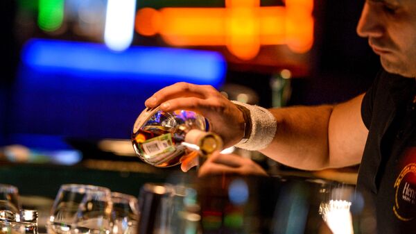 Бармен разливает напитки, стоя за барной стойкой в клубе - 俄羅斯衛星通訊社