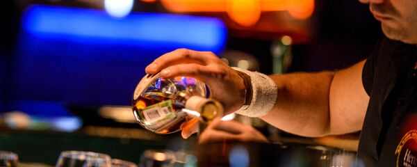 Бармен разливает напитки, стоя за барной стойкой в клубе Бармен разливает напитки, стоя за барной стойкой в клубе - 俄罗斯卫星通讯社