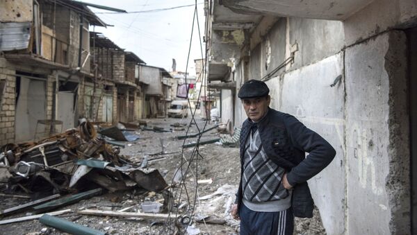 Мужчина на разрушенной улице города Степанакерт, который подвергся обстрелу.  - 俄罗斯卫星通讯社
