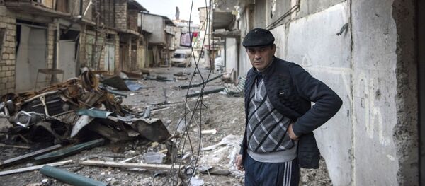 Мужчина на разрушенной улице города Степанакерт, который подвергся обстрелу.  - 俄罗斯卫星通讯社