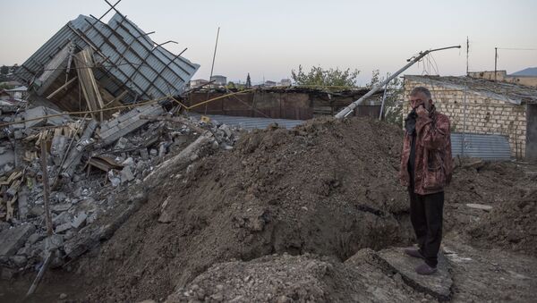 Мужчина осматривает жилой дом, разрушенный в результате обстрелов города Степанакерт - 俄罗斯卫星通讯社