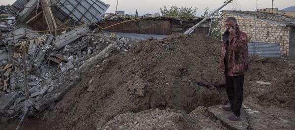 Мужчина осматривает жилой дом, разрушенный в результате обстрелов города Степанакерт - 俄羅斯衛星通訊社