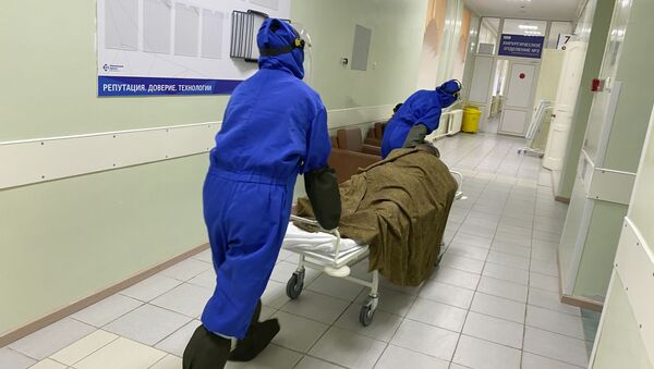 Медики везут пациента на носилках по коридору ковидного моногоспиталя, организованного на базе Областной клинической больницы № 1 в Тюмени. - 俄羅斯衛星通訊社