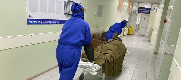 Медики везут пациента на носилках по коридору ковидного моногоспиталя, организованного на базе Областной клинической больницы № 1 в Тюмени. - 俄羅斯衛星通訊社