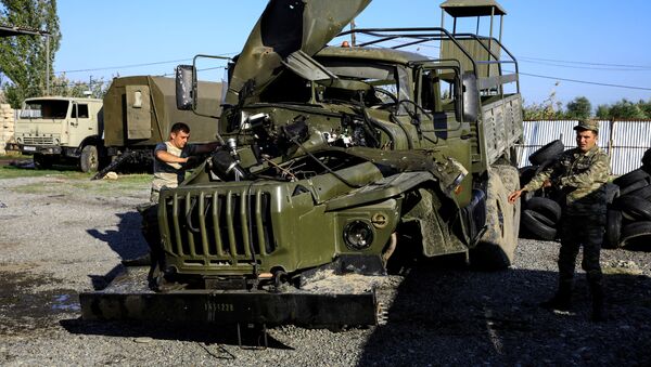 Солдаты осматривают поврежденный армянский военный грузовик, захваченный азербайджанской армией во время боев за самопровозглашенный Нагорный Карабах в районе города Барда. - 俄罗斯卫星通讯社