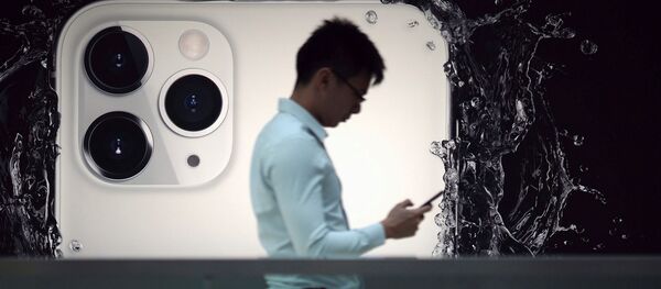 Мужчина на фоне рекламы iPhone 11 Pro - 俄罗斯卫星通讯社