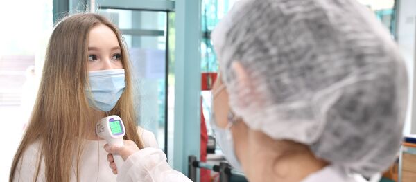 Ученице школы №2030 измеряют температуру перед началом сдачи единого государственного экзамена по литературе. Ученице школы №2030 измеряют температуру перед началом сдачи единого государственного экзамена по литературе. - 俄罗斯卫星通讯社