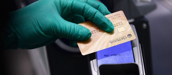 Покупатель оплачивает покупку банковской картой на кассе - 俄羅斯衛星通訊社