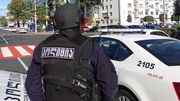 Полицейский возле филиала Банка Грузии в центре Зугдиди, где вооруженный мужчина захватил заложников. В заложниках 19 человек - сотрудники банка и клиенты.  - 俄羅斯衛星通訊社