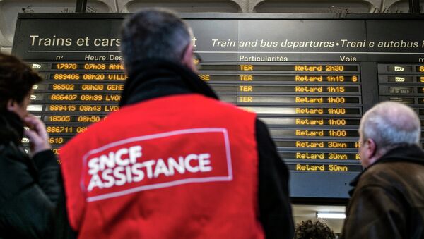 People stand next to a member of SNCF customer service staff in front of a board displaying departure information indicating that all trains have been delayed at Lyon-Part-Dieu railway station in Lyon - 俄罗斯卫星通讯社