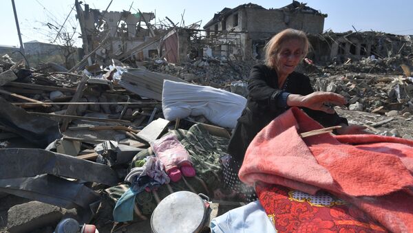 Жительница Гянджи собирает свое имущество на месте разрушенного после обстрела дома - 俄羅斯衛星通訊社