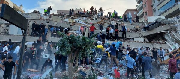 Спасатели и местные жители эвакуируют пострадавших во время обрушения здания в результате землетрясения, Измир, Турция - 俄罗斯卫星通讯社