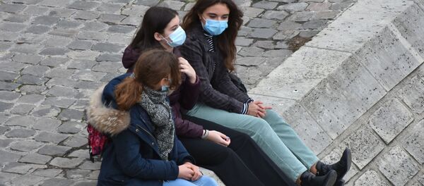 Девушки в масках на площади у входа в музей Лувр в Париже - 俄罗斯卫星通讯社