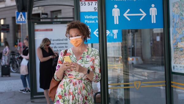 Женщина в маске на автобусной остановке в Стокгольме - 俄羅斯衛星通訊社