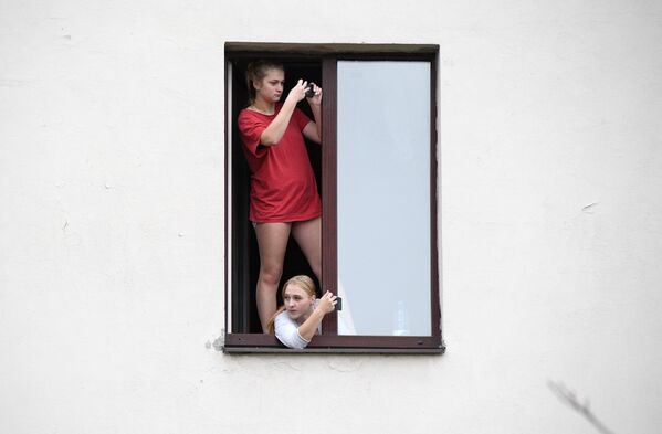 Жительницы Минска в окне дома во время несанкционированной властями акции протеста Партизанский марш - 俄罗斯卫星通讯社