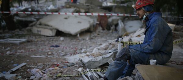 Спасатель во время отдыха на месте разрушенного здания после землетрясения в Измире Спасатель во время отдыха на месте разрушенного здания после землетрясения в Измире - 俄罗斯卫星通讯社
