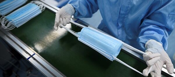 A worker checks masks at Naton Medical Group, a company which makes medical equipment in Beijing on April 24, 2020. - At a mask factory in a Beijing suburb, workers in blue protective suits are operating machine tools around the clock: the Chinese company is preparing a 188 million items ordered for France. (Photo by WANG ZHAO / AFP) - 俄罗斯卫星通讯社