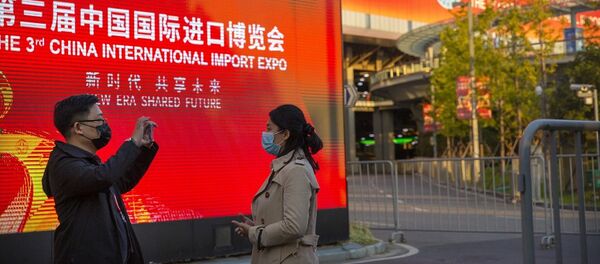 People wearing face masks to protect against the coronavirus take photos at the China International Import Expo in Shanghai, Wednesday, Nov. 4, 2020. - 俄羅斯衛星通訊社