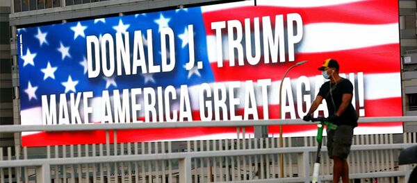 A man rides his scooter by a banner supporting U.S. President Donald Trump on a bridge along a highway, ahead of the upcoming U.S. election, in Tel Aviv, Israel October 28, 2020. - 俄罗斯卫星通讯社