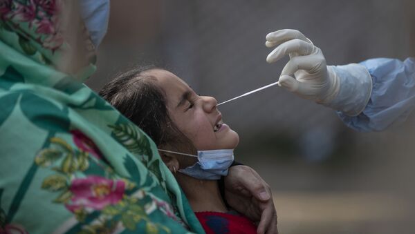 Медработник берет тест на коронавирус у ребенка в Индии - 俄羅斯衛星通訊社