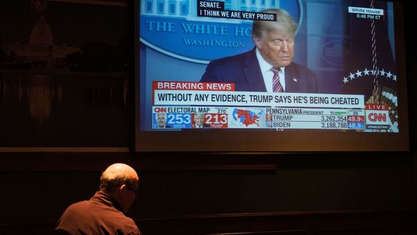 Мужчина смотрит трансляцию выступления американского президента Дональда Трампа в баре неподалеку от Белого дома в Вашингтоне. - 俄羅斯衛星通訊社