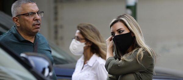 A woman adjusts her mask (COVID-19 coronavirus pandemic) as she walks along a street in Lebanon's capital Beirut on November 2, 2020. (Photo by JOSEPH EID / AFP) - 俄罗斯卫星通讯社