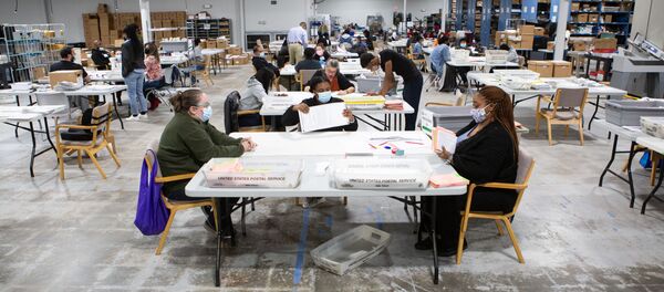 Сотрудники избирательных комиссий просматривают открепительные и временные бюллетени в офисе регистрации избирателей и выборов Гвиннетта в Лоуренсвилле, штат Джорджия - 俄罗斯卫星通讯社