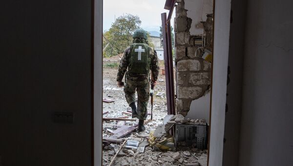 Военнослужащий возле дома, поврежденного в результате обстрела Степанакерта. - 俄羅斯衛星通訊社