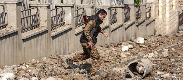 Вооруженный мужчина на месте обстрела в городе Шуша. - 俄羅斯衛星通訊社