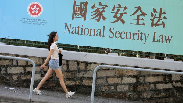Девушка на фоне плаката о национальном законе о безопасности в Гонконге - 俄罗斯卫星通讯社