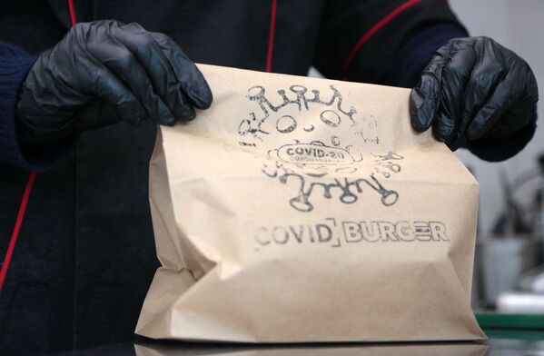 “新冠漢堡”小吃店內的工作人員拿著漢堡袋子 - 俄羅斯衛星通訊社