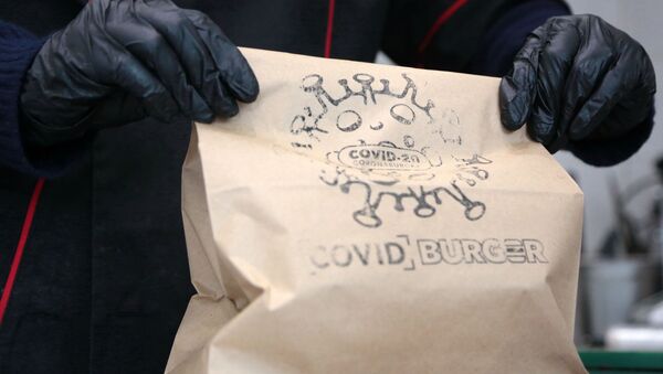 Сотрудница держит в руках пакет с бургерами в закусочной COVID-Burger в Севастополе - 俄罗斯卫星通讯社