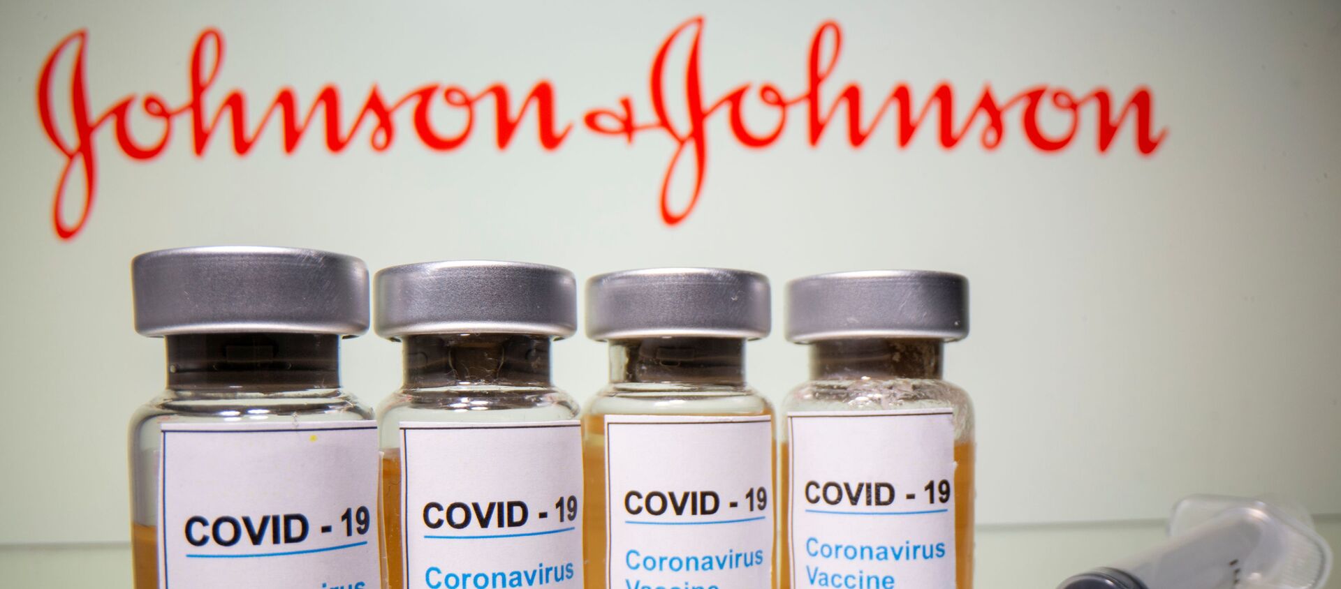Флаконы с надписью Вакцина от COVID-19 на фоне логотипа  Johnson & Johnson - 俄羅斯衛星通訊社, 1920, 27.02.2021