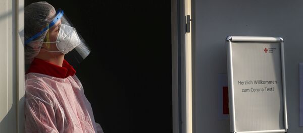 A member of Germany's Red Cross medical staff waits for people at a newly installed drive- and walk-in corona test centre as the spread of the coronavirus disease (COVID-19) continues in Frankfurt A member of Germany's Red Cross medical staff waits for people at a newly installed drive- and walk-in corona test centre as the spread of the coronavirus disease (COVID-19) continues in Frankfurt - 俄羅斯衛星通訊社