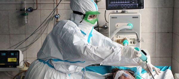 Медицинский работник и пациент в отделении интенсивной терапии ковид-госпиталя, организованного в городской больнице имени Л. Я. Литвиненко в городе Новоалтайске - 俄羅斯衛星通訊社