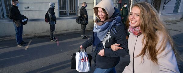 Девушки проходят около очереди призывников на сборном пункте в Санкт-Петербурге - 俄羅斯衛星通訊社