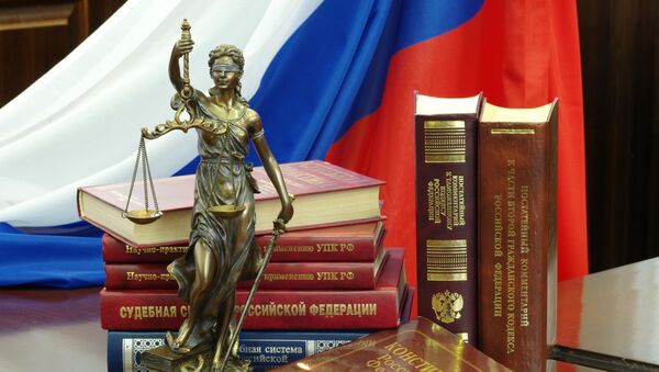 Статуя Фемиды и юридическая литература на столе в зале судебных заседаний - 俄羅斯衛星通訊社