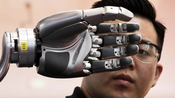 Посетитель разглядывает роботизированную руку, приводимую в движение перчаткой Kinfinity Glove, в Международном выставочном центре в Пекине, Китай, 2017 год - 俄罗斯卫星通讯社