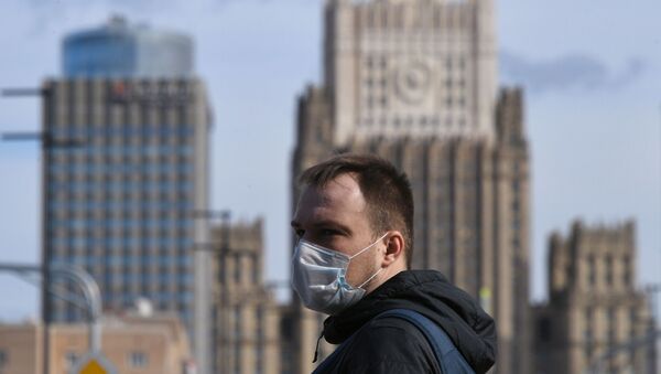 Мужчина в медицинской маске на фоне МИД России - 俄羅斯衛星通訊社