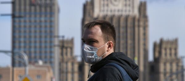 Мужчина в медицинской маске на фоне МИД России - 俄罗斯卫星通讯社