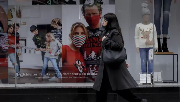 A woman wearing a face shield walks past the front window of the Primark clothing store on Oxford Street during England's second coronavirus lockdown, in London, Monday, Nov. 23, 2020 - 俄羅斯衛星通訊社